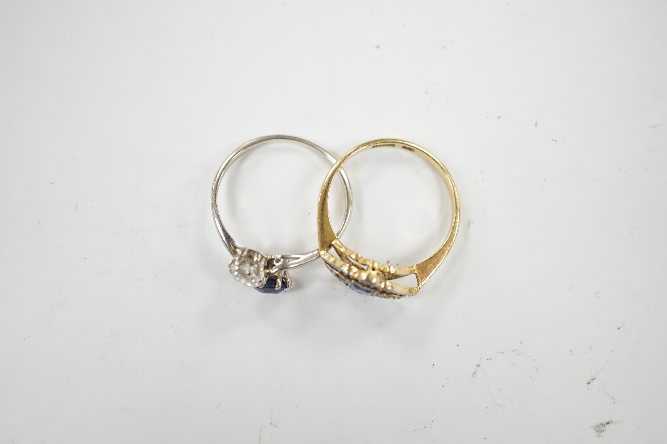 An early 20th century 18ct and plat, sapphire and diamond set cluster ring (stone missing), size N/O and a white metal, sapphire and diamond set two stone crossover ring, size M, gross weight 4.6 grams.